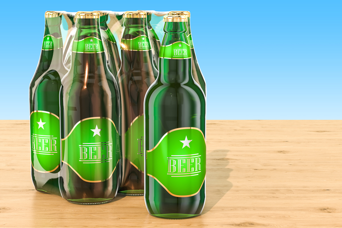 Package of glass beer bottles in shrink film on the wooden table, 3D rendering